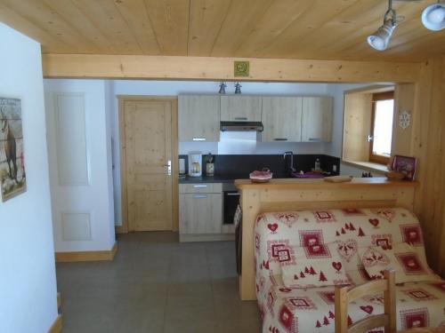 - une cuisine avec une table et un comptoir dans une pièce dans l'établissement La Bartavelle, à La Giettaz