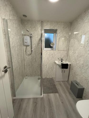 a bathroom with a shower and a sink at Sundial Cottage in Newton Abbot