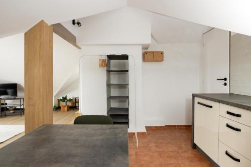 an open kitchen and dining room with a staircase in the background at BALANCE apartments - CAPPUCCINO in Znojmo