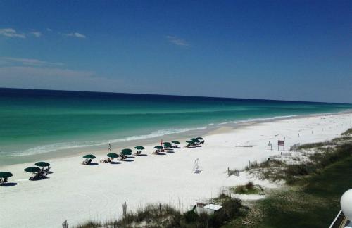 a beach with umbrellas and people on the beach at Destin Towers 1E in Panama City