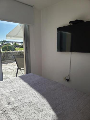 a bedroom with a bed and a television on the wall at Apart Altos del Virrey in Colonia del Sacramento