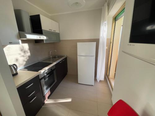 une petite cuisine avec un réfrigérateur et un évier dans l'établissement Lovely Sunny Studio, à Menton