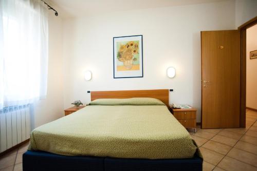 a bedroom with a bed with a green comforter at Hotel La Toscana in Arezzo