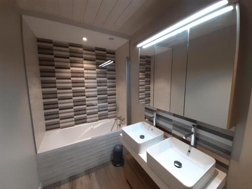 une salle de bain avec un lavabo, une baignoire et un miroir dans l'établissement Appartement skis aux pieds, 3 chambres, rénové, idéalement situé près des commerces à Courchevel 1650 - FR-1-514-61, à Courchevel