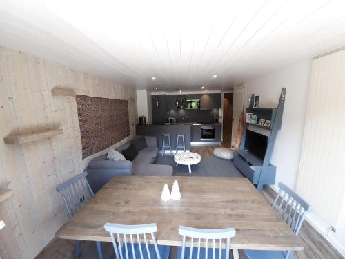 - un salon avec une grande table et des chaises en bois dans l'établissement Appartement skis aux pieds, 3 chambres, rénové, idéalement situé près des commerces à Courchevel 1650 - FR-1-514-61, à Courchevel