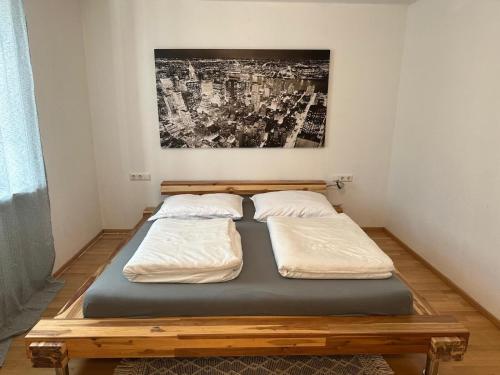 two beds in a bedroom with a painting on the wall at Mino Apartment in Bludenz