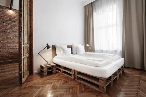a bedroom with a large bed in a room with a window at CityNest Apartments in Kraków