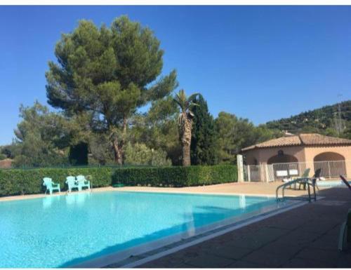 une piscine avec deux chaises et une maison dans l'établissement Appartement vue mer clim 4 personnes résidence boulouris Panorama, à Saint-Raphaël