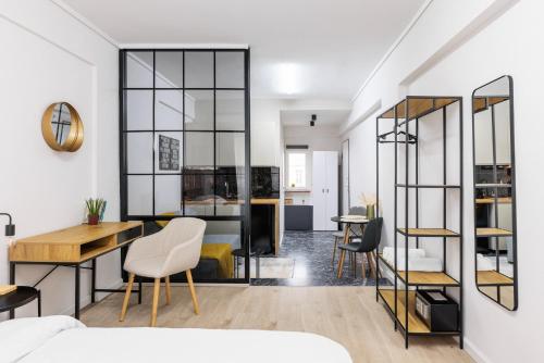 a room with a bed and a desk and chairs at B&M Suites in Thessaloniki
