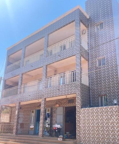 a brick building with a balcony on the side of it at Seven Apartments in Serekunda