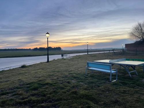 a bench and a table next to a river at Mallona in Pedro Rodríguez