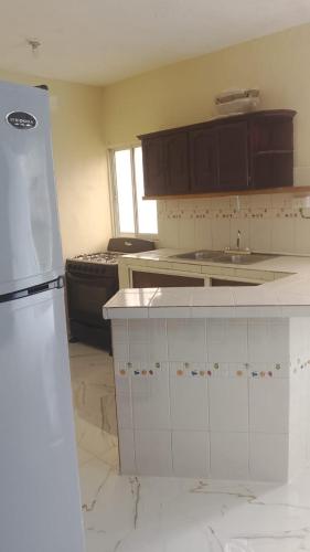 a kitchen with white counter tops and a refrigerator at Residencial A&H in Boca Chica
