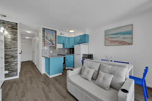 a living room with a couch and a kitchen at Bleu Oasis in Galveston