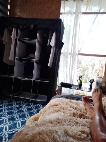 a person laying on a bed in a bedroom at Bugambilia house in La Tinguiña