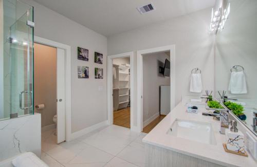 a white bathroom with a sink and a shower at Comfort exceed in this 3 BR premium in Houston! in Houston
