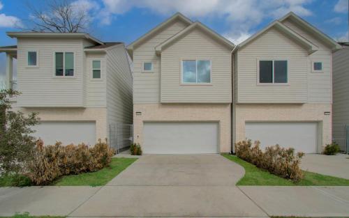 a house with two garage doors in a driveway at Comfort exceed in this 3 BR premium in Houston! in Houston