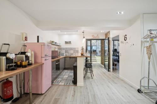 a kitchen with a pink refrigerator and wooden floors at Résidence AURMAT - Appart - Hôtel - Boulogne - Paris in Boulogne-Billancourt