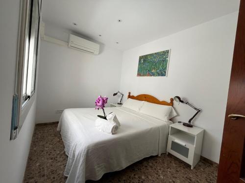 a white bedroom with a bed with flowers on it at Zen mar; Confort & Relax centro Calafell in Calafell