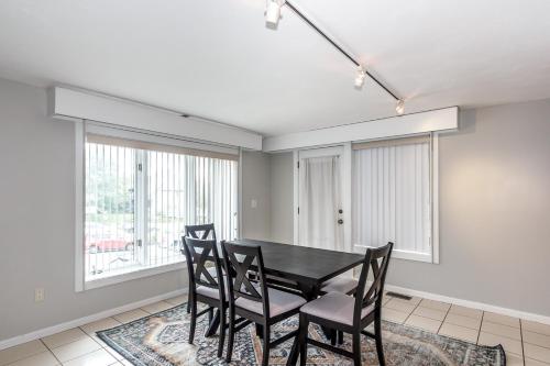 a dining room with a black table and chairs at 3 bed 2 bath pet friendly townhome in Londonderry