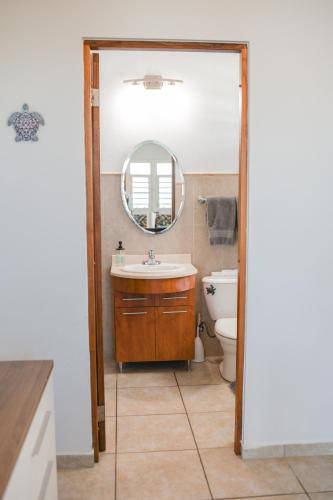 a bathroom with a sink and a mirror and a toilet at Island Charm Culebra - Studios & Suites - Amazing Water views in Culebra Puerto Rico! in Culebra