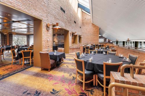 a restaurant with tables and chairs and a brick wall at Crowne Plaza Minneapolis West by IHG in Plymouth