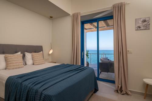 a bedroom with a bed and a view of the ocean at Astarte Villas Bleu Del Mar Villa in Argasi