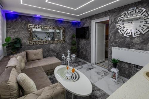 a living room with a couch and a clock on the wall at Matija Lux in Kraljevo