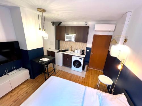 a small room with a bed and a kitchen at Pere Lachaise Apartments in Paris