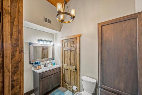 a bathroom with a toilet and a sink and a wooden door at Smoky's Lodge in Pigeon Forge