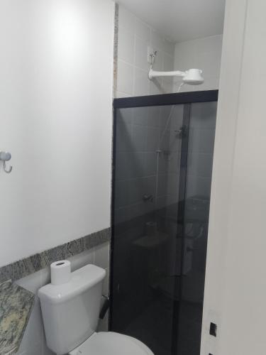 a bathroom with a toilet and a glass shower at flat no centro da Cidade in Campos dos Goytacazes