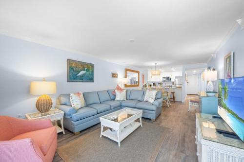 Una sala de estar con un sofá y un televisor. en Pelicans Roost 306 condo, en Sanibel