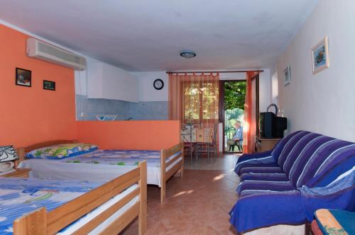 een slaapkamer met 2 bedden en een bank bij Apartment Dinono in Pula