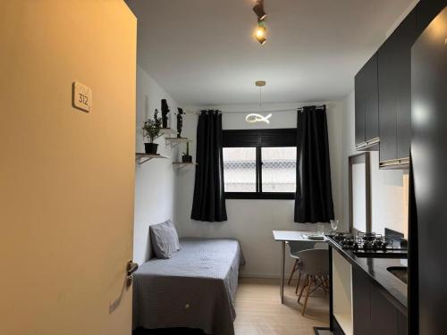 a small room with a kitchen and a table at 3-Apto Studio Liberdade 450' Metrô -Teatro Renault in Sao Paulo