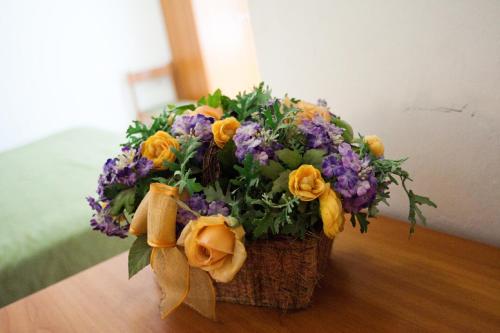 a bouquet of flowers in a basket on a table at Hotel La Toscana in Arezzo