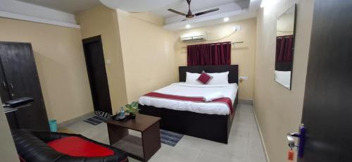 a hotel room with a bed and a chair at The Hygge Guest House in Kolkata