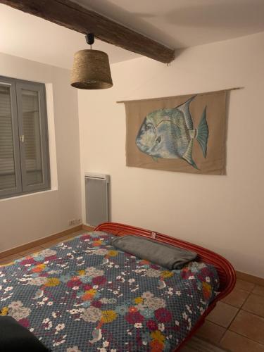 a bedroom with a bed with a fish painting on the wall at Duplex T3 climatisé centre terrasse parking payant in Manosque