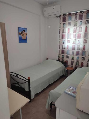 a small room with two beds and a window at Filina's Room 1 in Maltezana