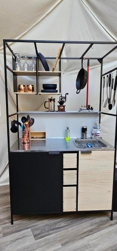 a kitchen with a black counter top in a tent at Glamping with the Stars, Aquarius in Hadashville