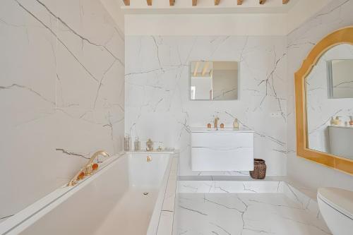 une salle de bain blanche avec une baignoire et un lavabo dans l'établissement Rooftop Victor Hugo, à Paris