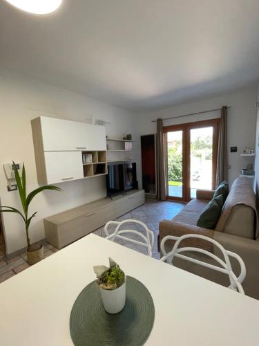 een woonkamer met een tafel en een bank bij Casa Fralia in Olbia