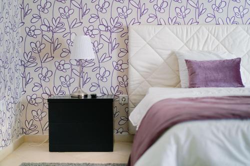 a bedroom with a bed and a table with a lamp at Alojamento Galerias Nascentes in Alijó