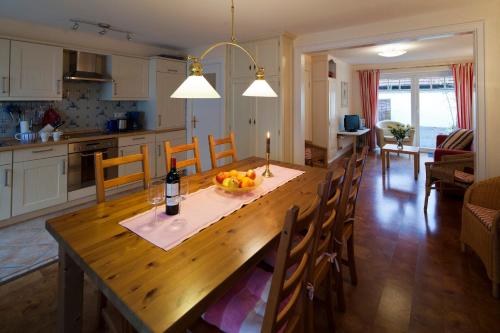 a kitchen and dining room with a large wooden table at Altstadtflair Apartment in Husum