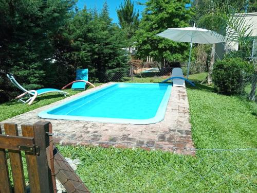 una piscina en un patio con sillas y sombrilla en El Sosiego Posada de Campo, en Colón