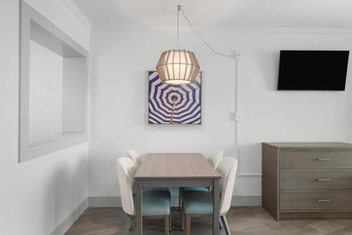 a dining room with a table and chairs and a tv at Compass Cove in Myrtle Beach