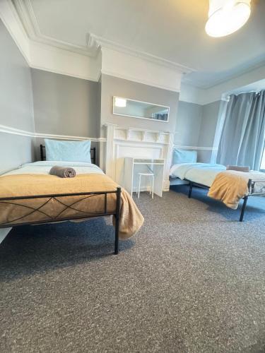 a bedroom with two beds and a desk in it at Shirley House 6, Guest House, Self Catering, Self Check in with smart locks, use of Fully Equipped Kitchen, close to City Centre, Ideal for Longer Stays, Excellent Transport Links in Southampton