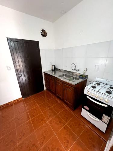 eine Küche mit Herd und Spüle in der Unterkunft Maraja318X in Mar de Ajó