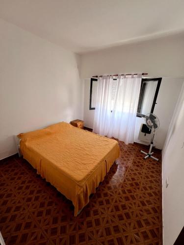Schlafzimmer mit einem Bett und einem Ventilator in der Unterkunft Maraja318X in Mar de Ajó