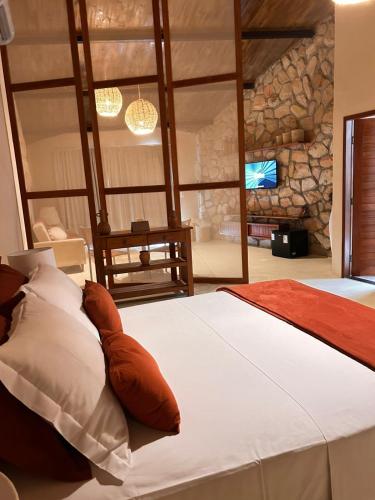 a bedroom with a large bed with a stone wall at La Belle Resort Lago Azul in Nísia Floresta