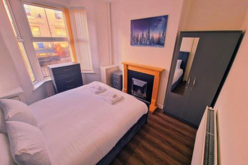 a small bedroom with a bed and a fireplace at Beautiful home near LFC Stadium in Liverpool