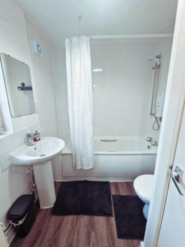 a bathroom with a sink and a tub and a toilet at Beautiful home near LFC Stadium in Liverpool